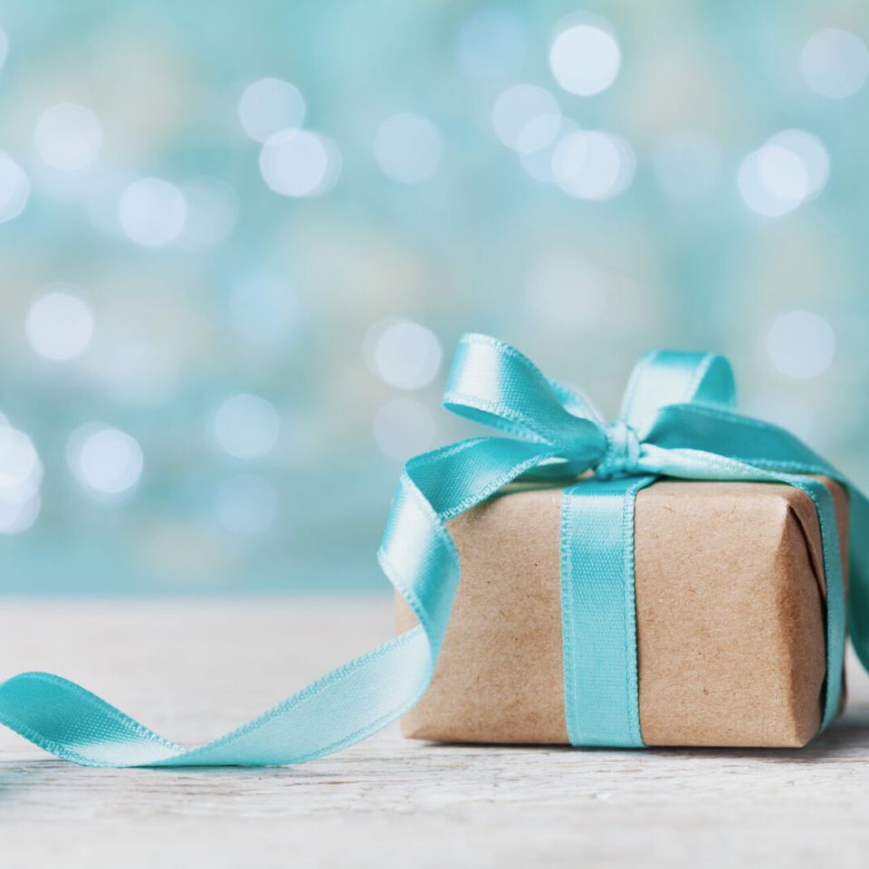 A cute little gift box with a cyan color ribbon